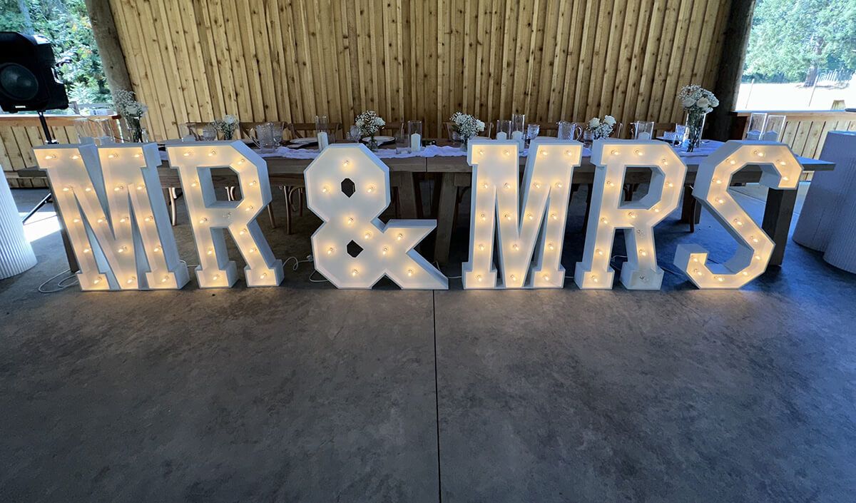 Timeless Party Rentals Mr and Mrs Prop with lights at event